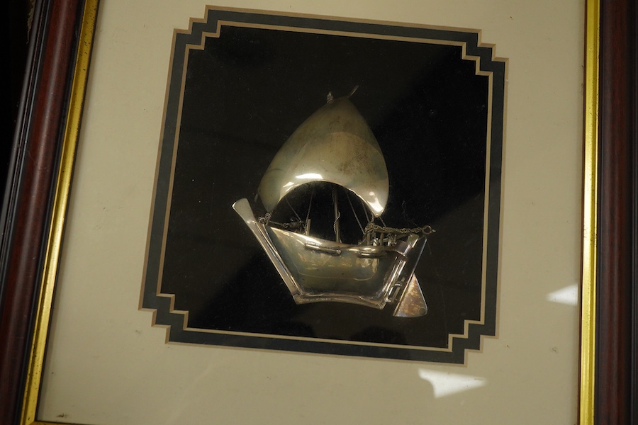 A glass framed white metal khanjar and a similar dhow, together with part model of a Dallah, 16.3cm.